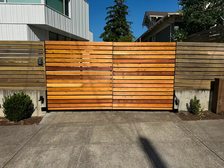 Horizontal cedar slat automatic driveway gate with keypad, sunlit