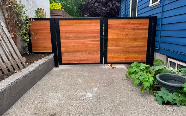 Horizontal cedar swing driveway gate with steel frame, angled side-yard view — Interstate Gate Repair