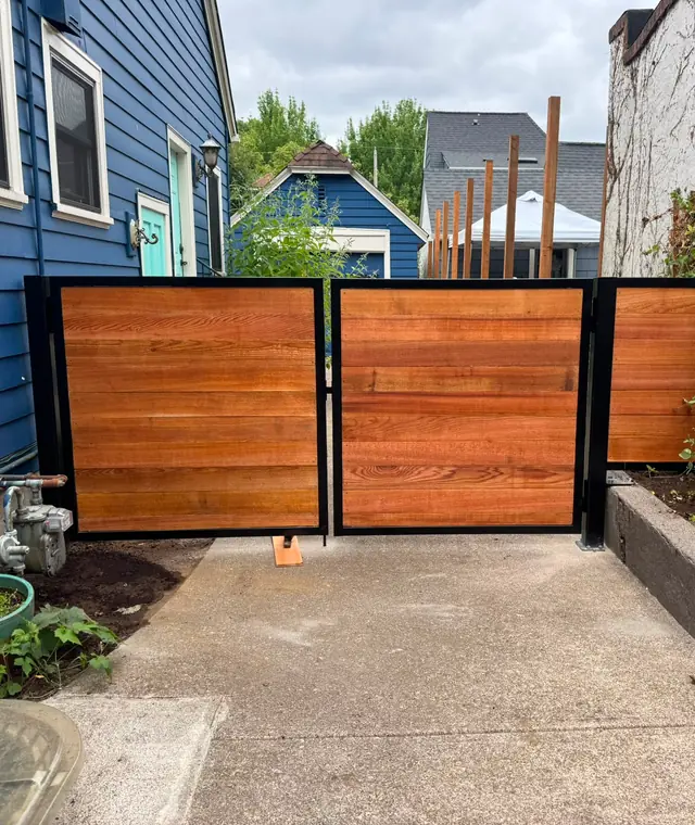 Modern horizontal cedar double swing gate with black steel frame in side yard — Interstate Gate Repair