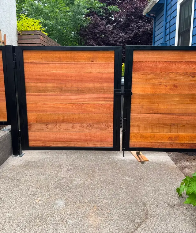Horizontal cedar swing gates with black steel frames in narrow side yard — Interstate Gate Repair