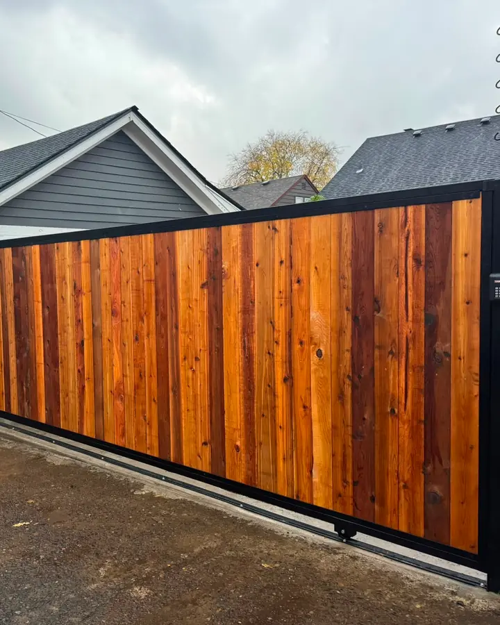 Cedar sliding driveway gate with LiftMaster keypad along paved alley — Interstate Gate Repair