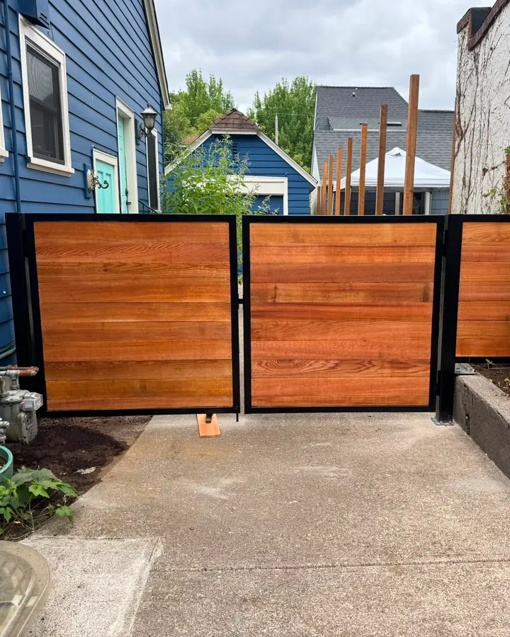 Modern horizontal cedar double swing gate with black steel frame in side yard — Interstate Gate Repair