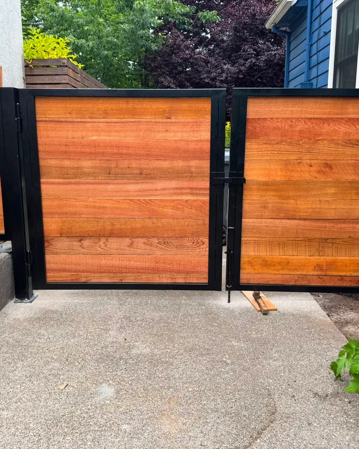 Horizontal cedar swing gates with black steel frames in narrow side yard — Interstate Gate Repair