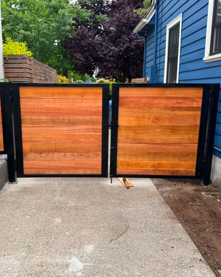Finished horizontal cedar gates with black steel frames across driveway — Interstate Gate Repair