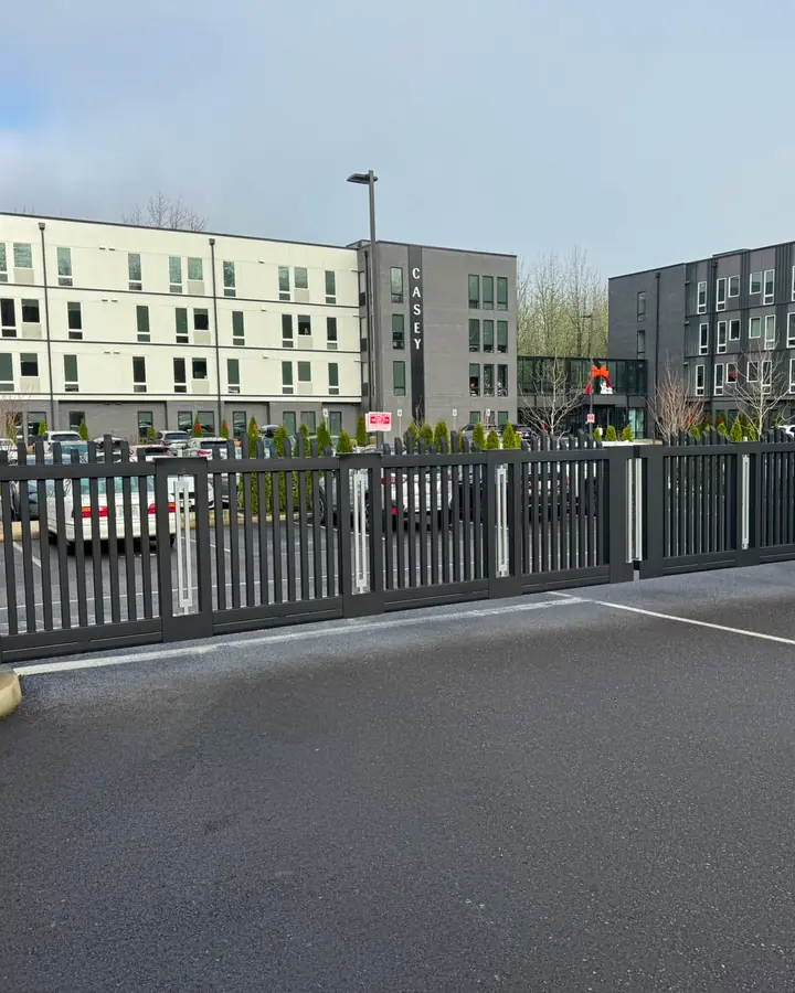 Black metal cantilever slide gate securing apartment parking lot at Casey building — Interstate Gate Repair