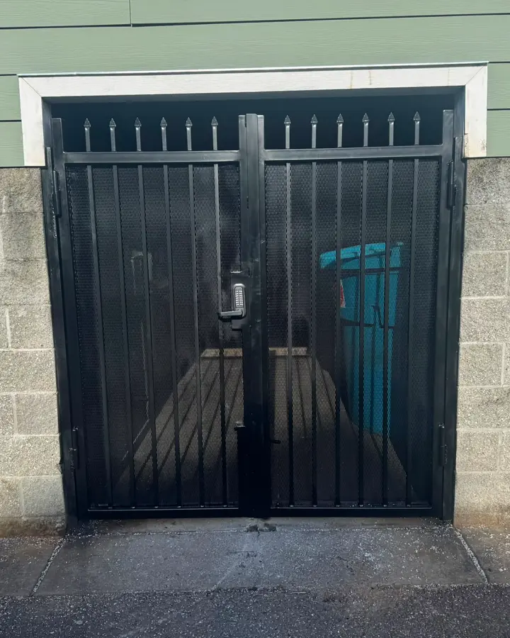 Black steel double security gate with spear tops and keypad on block wall — Interstate Gate Repair