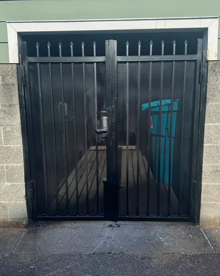 Black steel double security gate with spear tops and keypad, front view — Interstate Gate Repair
