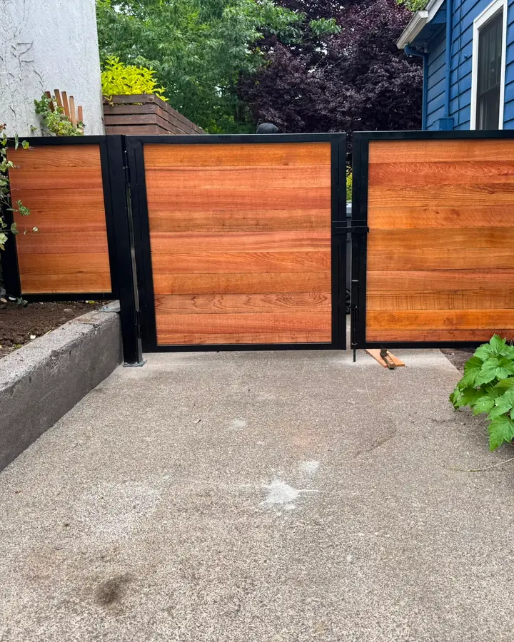 Horizontal cedar swing driveway gate with steel frame, angled side-yard view — Interstate Gate Repair