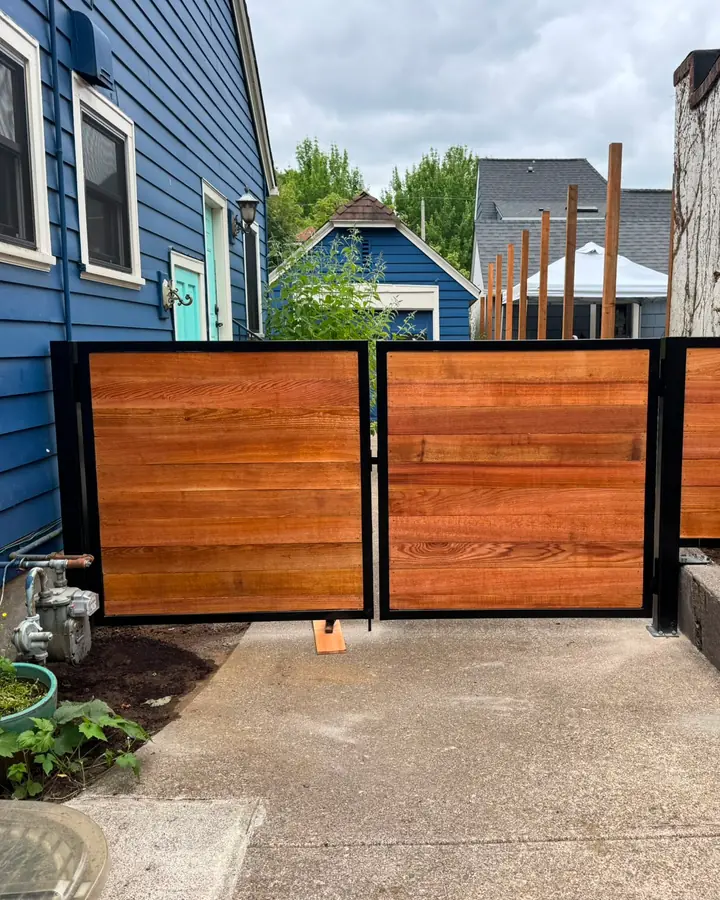 Finished cedar horizontal swing driveway gate in black frame, straight-on view — Interstate Gate Repair