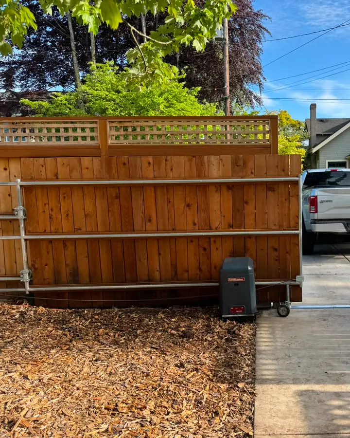 Finished cedar sliding driveway gate with LiftMaster operator beside parked Ford truck — Interstate Gate Repair