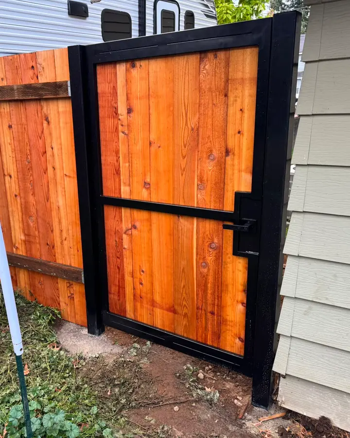 Black steel-frame cedar pedestrian gate between house and older wood fence, install area — Interstate Gate Repair